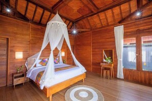 Ein Zimmer aus Holz mit einem Bett, einem kleinen Tisch und einem Fenster.