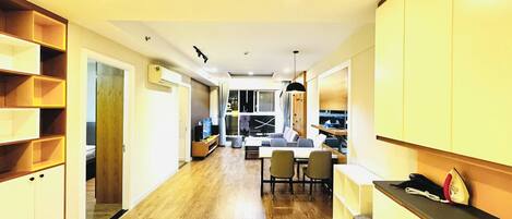 A modern kitchen with wooden cabinets, a dining area with chairs, and a visible kitchen counter.