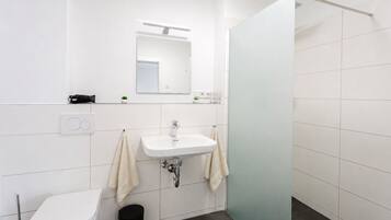 Ein modernes Badezimmer mit Toilette, Waschbecken und Dusche.