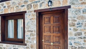 Un edificio de piedra con puerta de madera y una ventana.