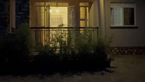 Ein Gebäude mit einer Veranda, einer Tür und einem Fenster.