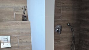 A bathroom with a shower, toilet, and a trash bin. - Exceptional villa, infinity pool, view of the marina and cliffs, close to beaches. (Albufeira)