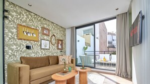 Una sala de estar moderna con sofá, mesa de centro y una obra de arte en la pared.
