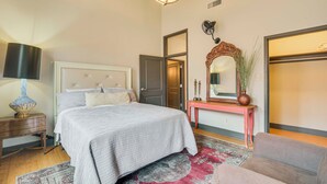 A bedroom with a bed, bedside table, lamp, dresser, and a mirror above a console table. - Walk to Events & Dining: Updated Brownwood Apt (Brownwood)