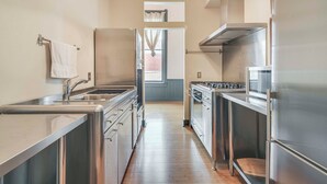 A modern kitchen with stainless steel appliances, a wooden countertop, and a view to the living area. - Walk to Events & Dining: Updated Brownwood Apt (Brownwood)