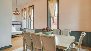 A dining area with a wooden table, chairs, a chandelier, and a bowl of decorative items on the table. - Walk to Events & Dining: Updated Brownwood Apt (Brownwood)
