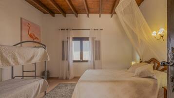 Un dormitorio con techo de madera, una cama con dosel, una mesita de noche y una lámpara fijada a la pared.