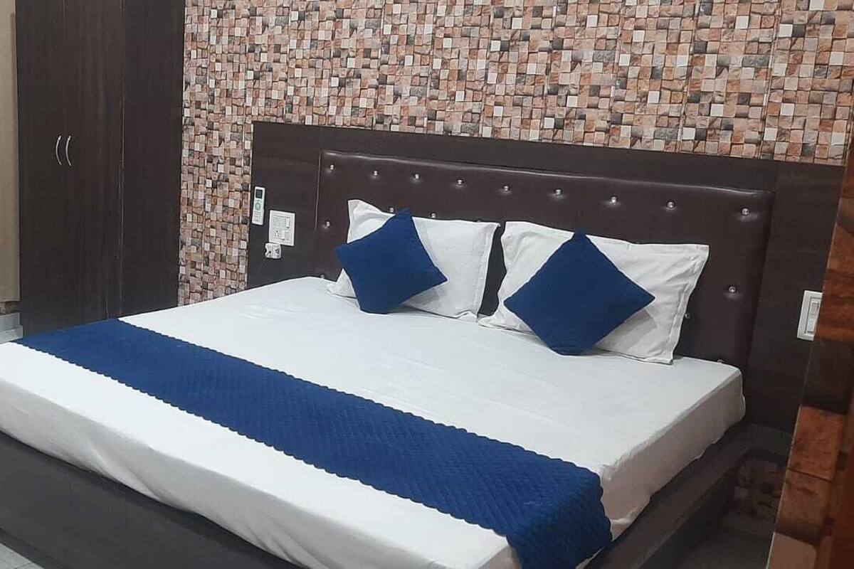 Un dormitorio con cama, mesita de noche, armario y sofá.