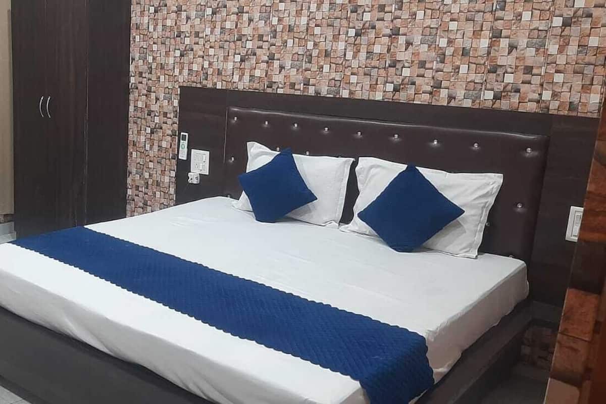 A bedroom with a bed, a nightstand, a wardrobe, and a sofa.