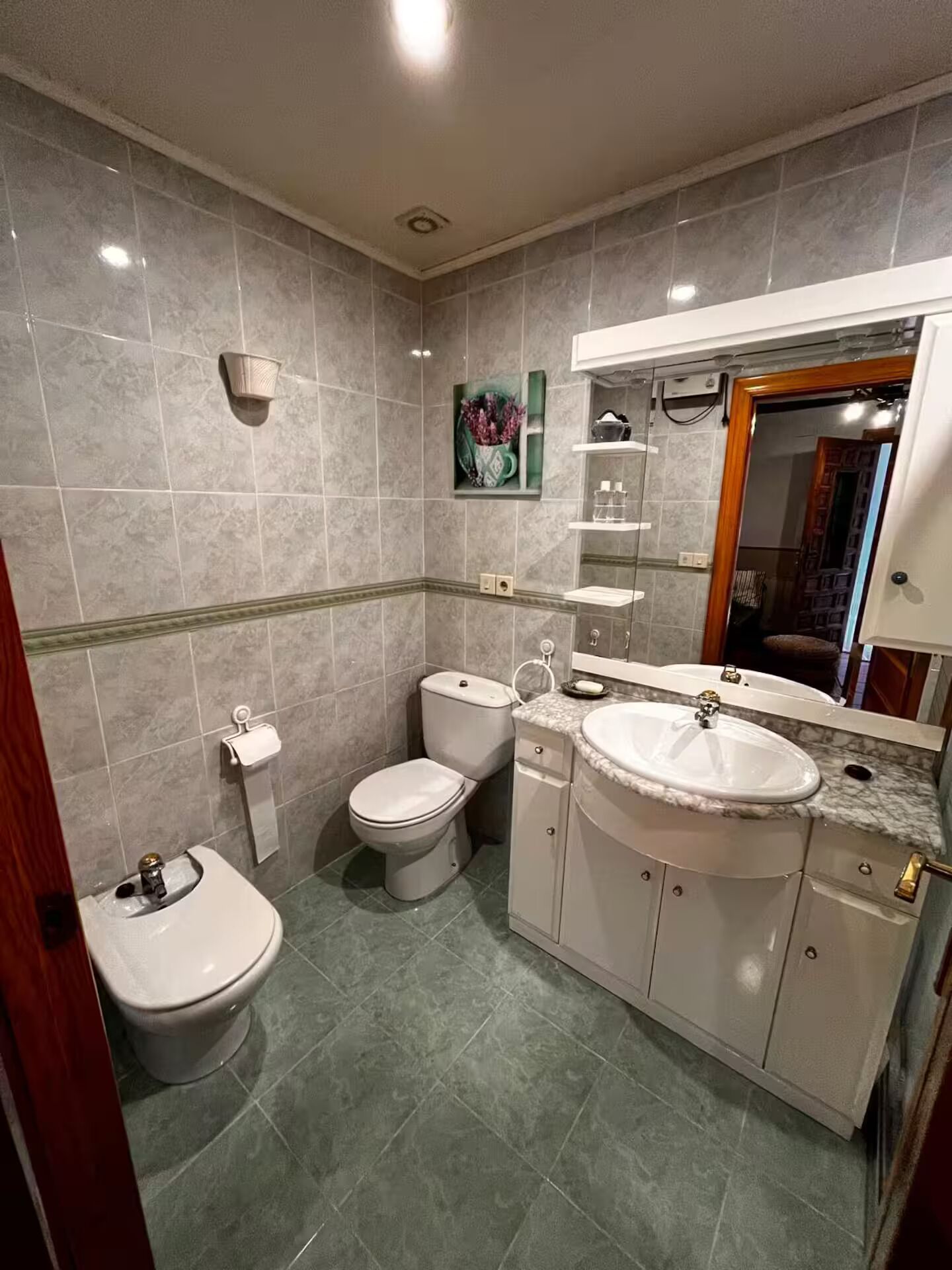 A bathroom with a toilet, bidet, and sink.
