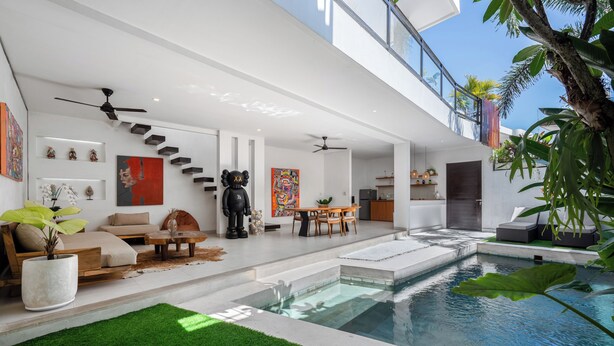 A modern interior with a pool, staircase, and indoor plants. - L'Angelo Villa Canggu (Canggu)