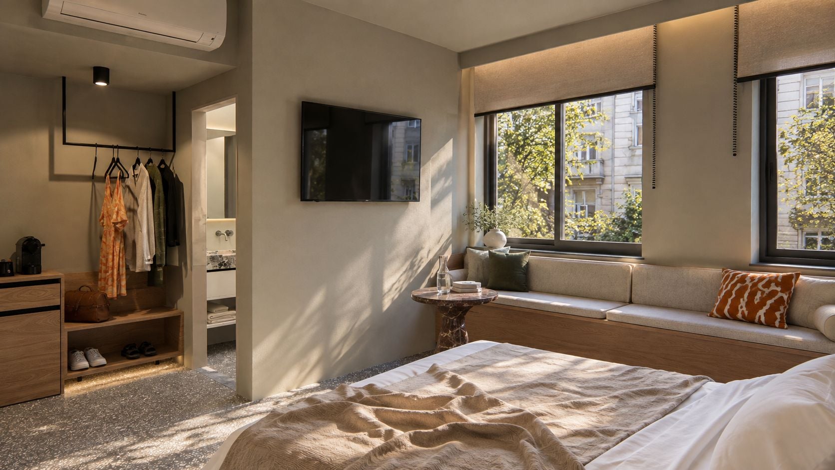 Un dormitorio moderno con cama, zona de estar con vistas, televisor y armario.