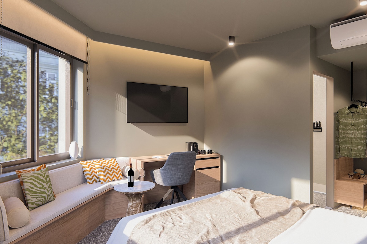 A modern bedroom with a bed, a desk, a chair, a sofa, a TV, and a wardrobe.