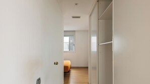 Un pasillo estrecho con una puerta a la izquierda y una ventana a la derecha.