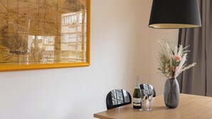 Una mesa de comedor con un mapa, una botella de vino y un jarrón con flores.
