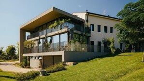A modern two-story building with a flat roof, large windows, and a balcony. - Stilla Rooms and Contemporary Cuisine (Colognola ai Colli)