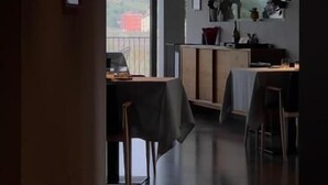 A modern interior with a dining area, a kitchen, and a view through a doorway. - Stilla Rooms and Contemporary Cuisine (Colognola ai Colli)