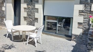 A building with a stone facade, a black door, and a glass sliding door.