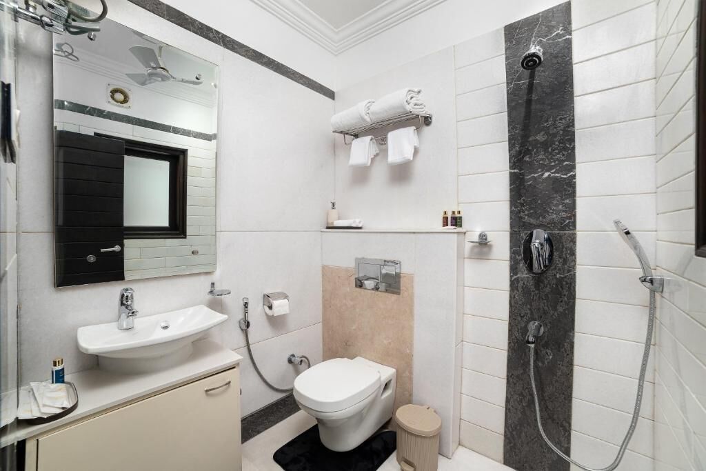 A modern bathroom with a sink, toilet, and shower.
