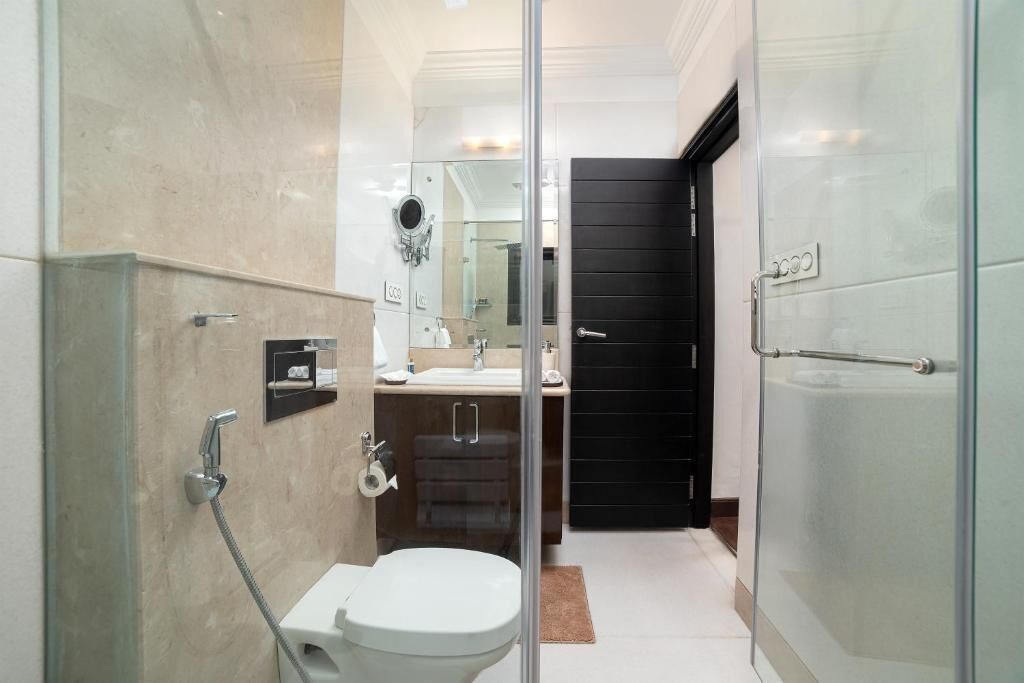 Un baño moderno con cabina de ducha de vidrio, inodoro y lavamanos.