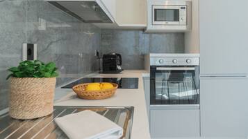 A modern kitchen with a built-in oven, microwave, and a coffee maker.