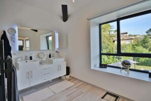 A modern bathroom with a large window, a vanity with a mirror, and a towel rack. - Villa Bella Vista # Pool - Luxury & Serenity (Le Cannet)