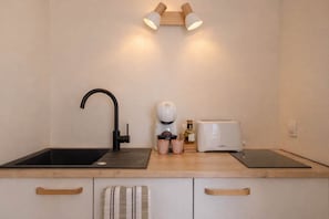 A kitchen with a black faucet, a coffee machine, a toaster, and a wooden countertop. - The Star of the Moure # Sea View - Beach - Port (Cannes)