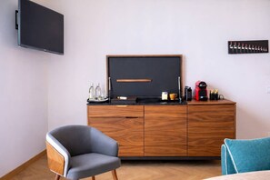 A modern room with a flat-screen TV, a wooden cabinet with a coffee machine, and two chairs. - Love Nest # Sea View - Close to Beach and Port (Cannes)