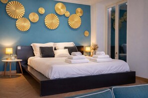 A modern bedroom with a large bed, bedside tables, and decorative wall art. - Love Nest # Sea View - Close to Beach and Port (Cannes)