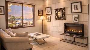 Una sala de estar con un sofá, una mesa de centro, una chimenea y cuadros en la pared.