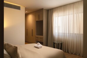 A hotel room with a bed, a small table, a wardrobe, and a window with curtains. - Breeze @ Lakeview Res I Nesty Hospitality (New Cairo City)