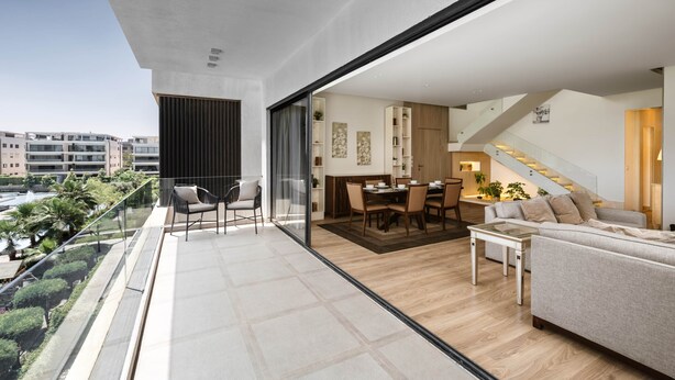 Un appartement moderne doté d’un balcon, d’un coin repas et d’un salon.