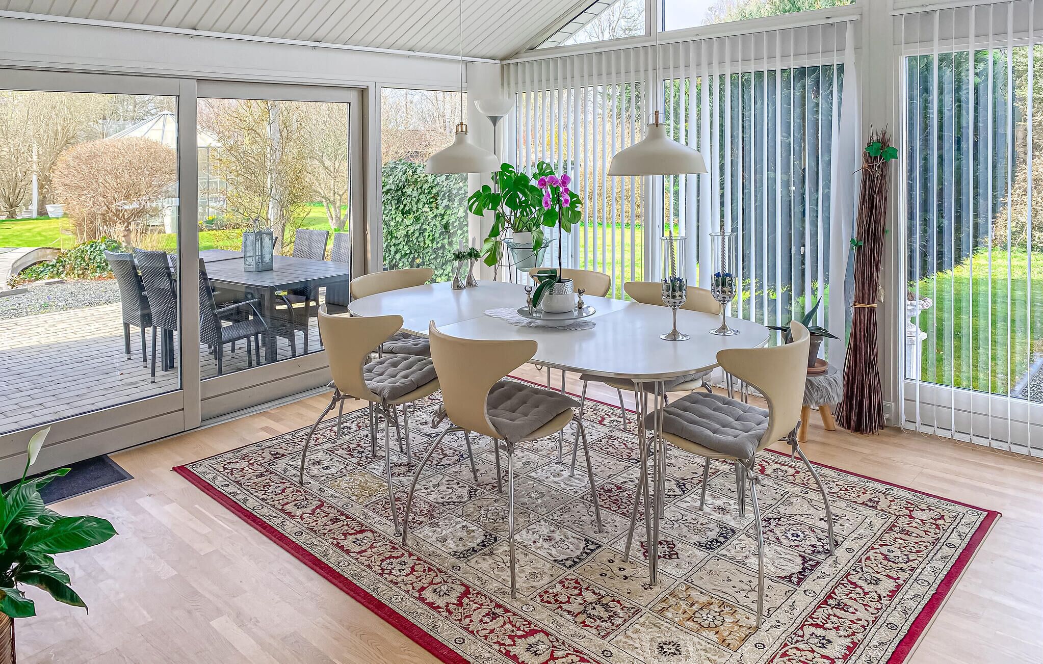 Un coin repas avec une table ronde, des chaises et un tapis à motifs.