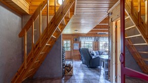 A wooden staircase leading to a living area with a sofa and a fireplace.