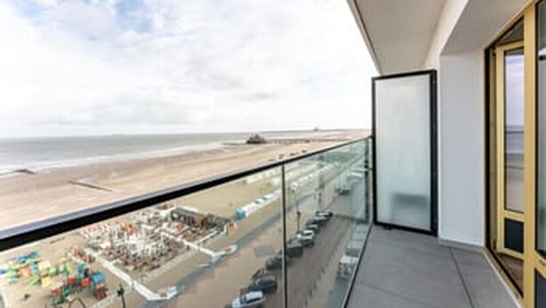 Ein Balkon mit Blick auf Strand und Meer.