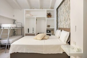Un dormitorio con literas, una mesita de noche, un armario y una pared con estampado.