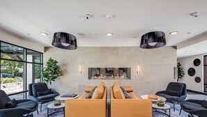 Un hall d’entrée doté d’une cheminée, de sièges modernes et de grandes fenêtres.