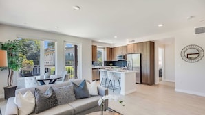 Un appartement moderne comprenant un salon, une cuisine et un coin repas.