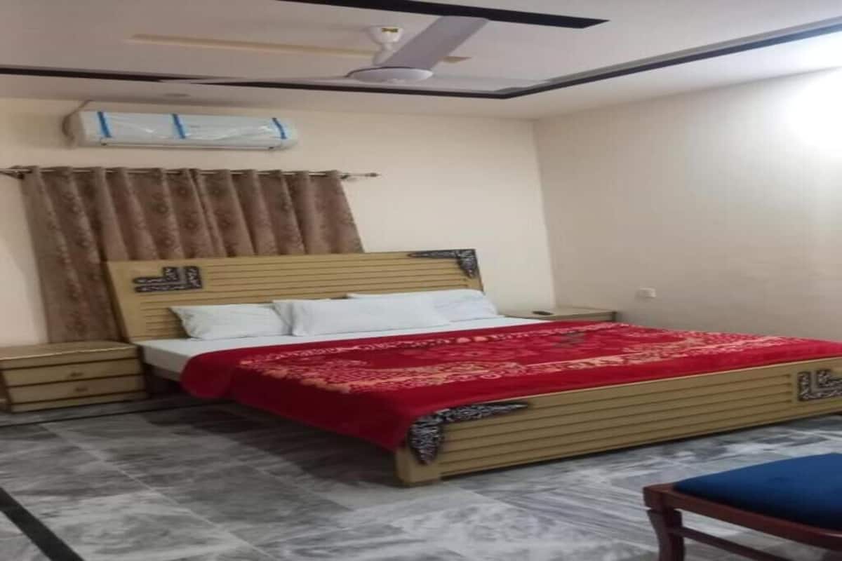 A bedroom with a bed, nightstands, a ceiling fan, and a window with curtains.