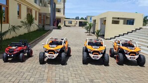 Four off-road vehicles parked on a paved driveway in front of a building with a staircase. - The Africana Hotel- Isiolo (Isiolo)