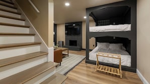 Une chambre moderne avec un escalier, une cheminée et un lit superposé.
