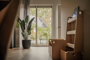 Ein Zimmer mit großem Fenster, einem Blumentopf und einer Holzbank.