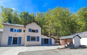 A two-story building with a flat roof, a small attached structure, and a gravel driveway. - MAISON AU COEUR DE LA NATURE (La Salvetat-sur-Agout)