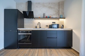 Eine moderne Küche mit Backofen, Kaffeemaschine und Spüle.