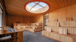 Un interior de madera con tragaluces, asientos integrados y una chimenea de piedra.