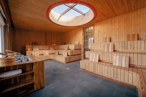 Un interior de madera con tragaluces, asientos integrados y una chimenea de piedra.