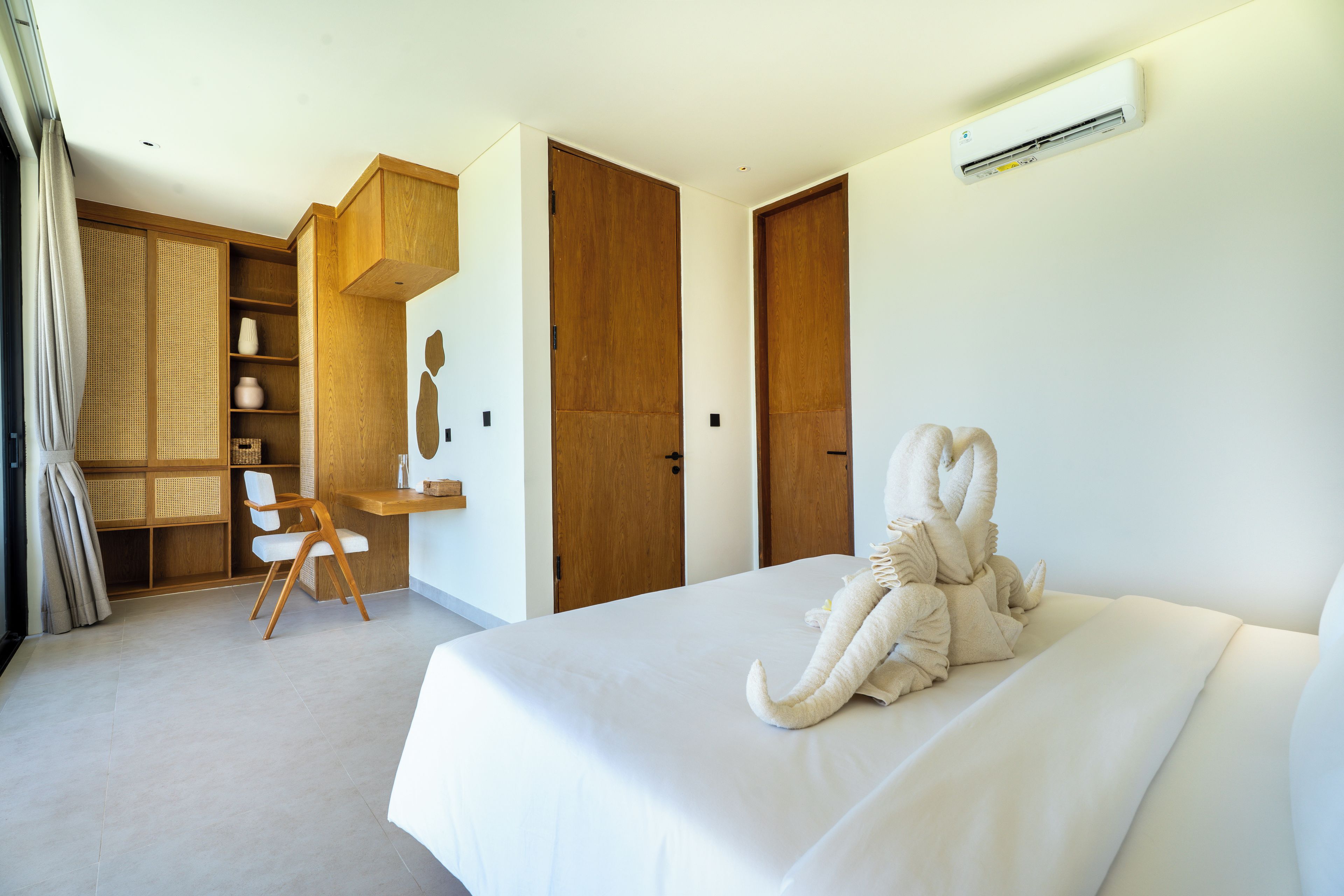Ein Hotelzimmer mit einem großen Bett, einem Schreibtisch mit Stuhl und einem Kleiderschrank.
