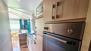 Eine moderne Küche mit Edelstahlgeräten, Holzschränken und einem Fenster.