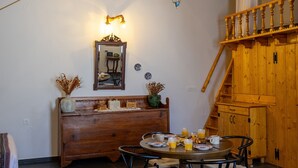 En matplats med ett runt bord, stolar och ett rustikt trätak.