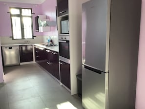 A modern kitchen with stainless steel appliances, a dishwasher, and a window with blinds. - Villa Le Chaland in Luxurious surroundings - Brighthelm Villas (Grand Baie)